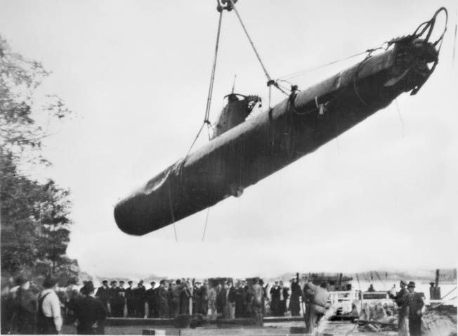一群围观者聚集在一起，目睹一艘日本小型潜艇从悉尼港的水中坟墓中升起。在这艘船上发现了两名日本船员的尸体，另一艘潜艇也被打捞上来。