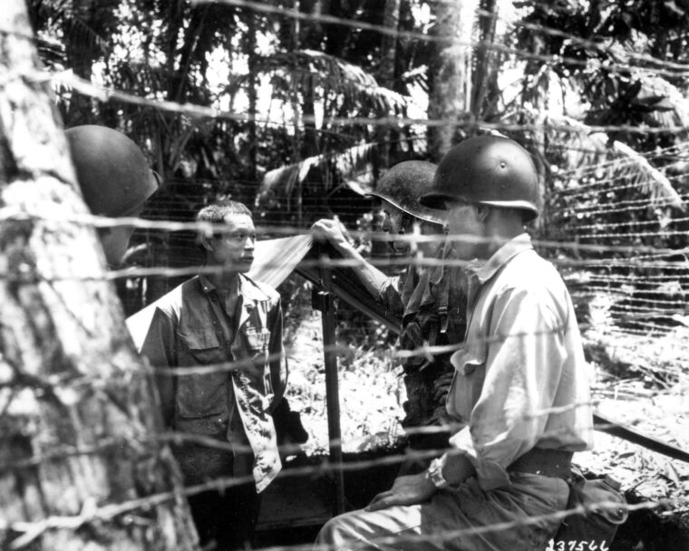 1943年9月12日,在维拉拉沐浴,新喀里多尼亚,约翰主要负担和Nisei士兵第25师语言的部分,附加到G2(军事情报),询问日本战俘在一个临时栅栏。
