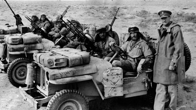 上校大卫·斯特灵的创始人SAS,姿势与他的几个男人在他们离开之前突袭。全副武装吉普车通常安装双维氏机枪和携带规定延长进军沙漠。