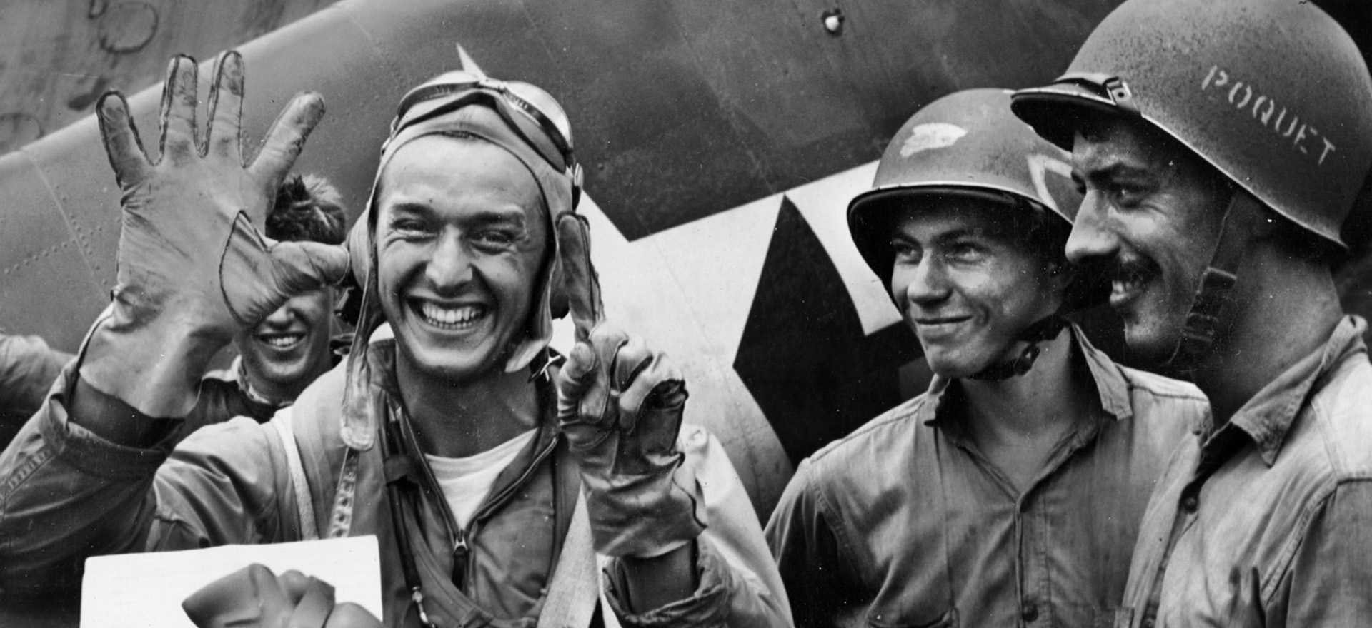 美国海军中尉亚历克斯·弗拉丘乌举起六个手指，表示在8分钟的时间里，在一次任务中被他击落的日本飞机的数量。