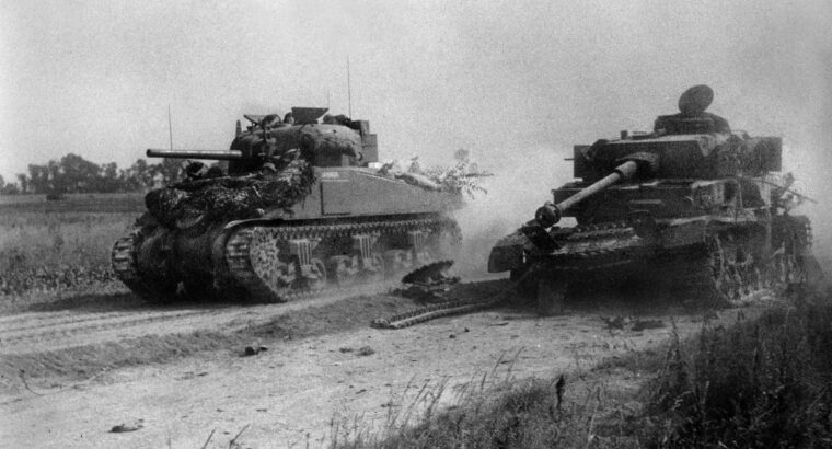 一辆英国M4谢尔曼中型坦克从一辆被击倒的德国PzKpfw旁飞驰而过。在诺曼底登陆后的几周里，为了争夺卡昂十字路口和通讯中心的控制权而进行的殊死战斗中。盟军的规划者预计卡昂将在诺曼底登陆当天落入英国手中;然而，盟军经过一个月的艰苦战斗才占领了这座城镇。