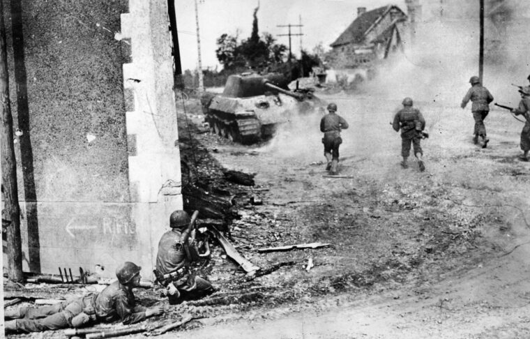 一个号。一辆黑豹中型坦克在被左下方发射火箭筒的美国步兵击中后冒烟。其他士兵冲向坦克，救出任何可能在爆炸中幸存下来的船员。在法国的迈伊里，第90步兵师的士兵彻底击败了德军106装甲旅的破坏进攻。