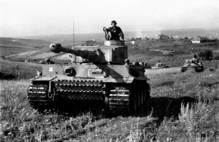 纳粹党卫军“帝国”师的一辆虎式坦克在库尔斯克突出部南部与苏军作战。它的88毫米火炮可以击穿1800码外的苏联T-34装甲。