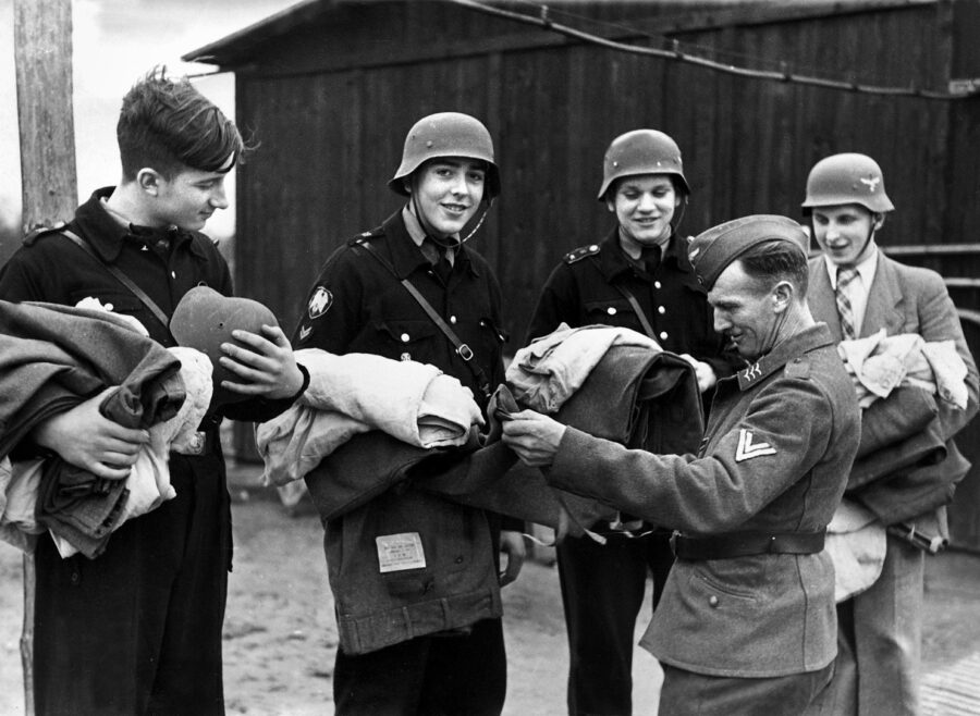 微笑的希特勒青年团成员,仍在平民外套和领带,发行他们的设备从一个区域在空军。