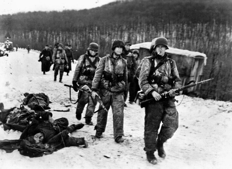 在匈牙利的春季觉醒行动中，一列武装党卫军士兵在雪地里艰难前行。德军的攻势受到雪、雨和深泥的阻碍，坦克和其他车辆陷入泥潭，需要步兵在有限的机械化支援下进行大部分战斗。