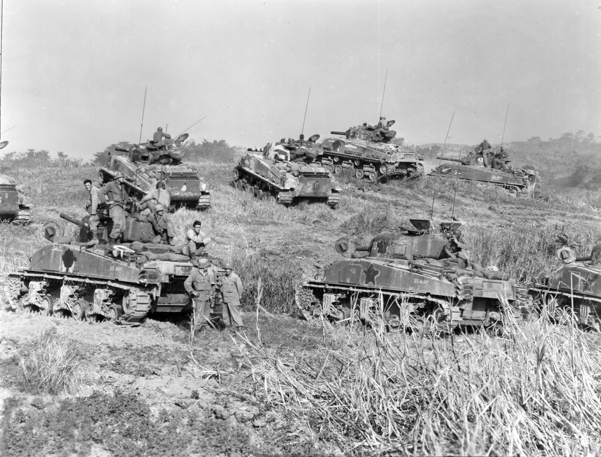 1945年4月，冲绳，美军第193坦克营的一组坦克在返回战斗前在M4谢尔曼坦克上和周围休息。注意坦克侧面的白色星星被涂掉了，以减少敌人的可见度。尽管如此，日本异常强大的抵抗还是使美国的坦克和油轮损失惨重。
