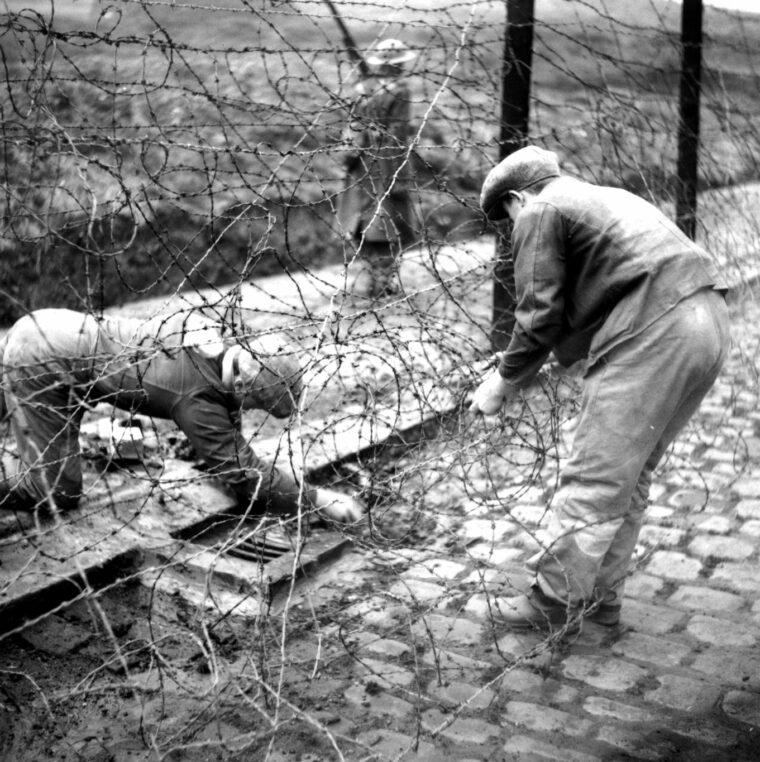 德国战俘劳工来修复受损的铁丝网流产后的格伦米尔营1944年12月逃跑的企图。